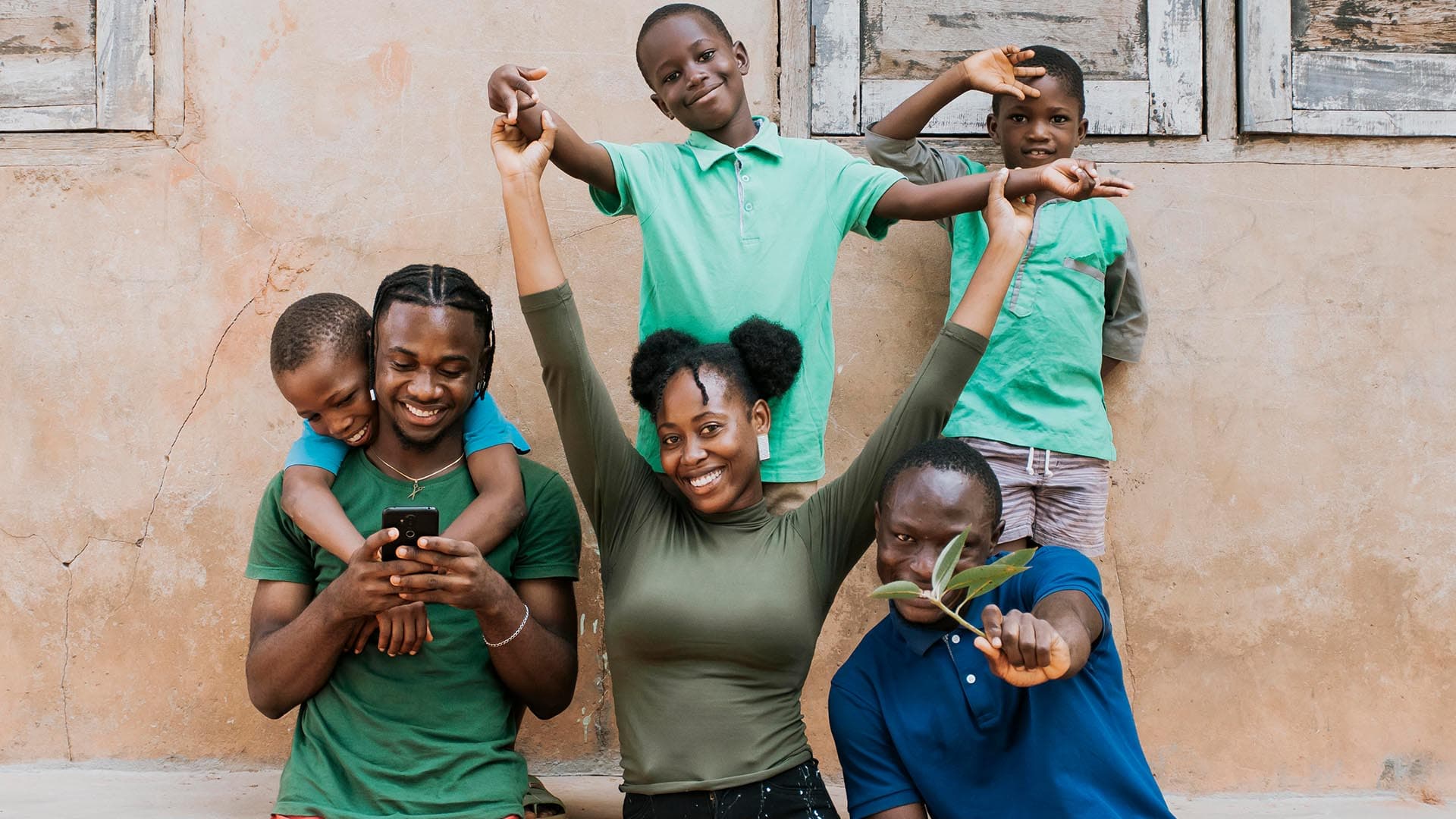 A family of different ages laughing together against a wall